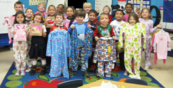 Kindergarten students at Little Flower School in Indianapolis pose on Jan. 4 with pajamas that they donated to charity. All grades at the Indianapolis East Deanery school are finding service organizations to partner with to help the students learn to be servant leaders. (Submitted photo)