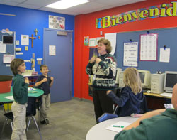 Spanish teacher Paula Owens leads a language exercise for Kennedy Gordon, left, Nathan Flora and Elyse Cullin, second-grade students at St. Malachy School in Brownsburg. (Submitted photo)