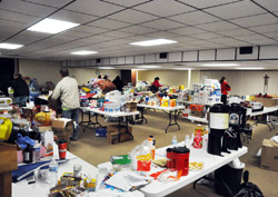 Volunteers sort donated relief items stored in the basement of St. Francis Xavier Church in Henryville on March 3. Since the church came through the March 2 tornado that ripped through the town relatively unscathed, it quickly became a center for the collection and distribution of food, clothing, blankets and other items to people affected by the storm. Within hours, the basement was filled with donations and some had to be stored in the church's worship space. (Photo by Sean Gallagher)