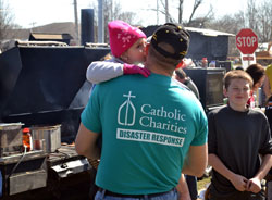 A Catholic Charities Disaster Response team member receives a kiss from a young girl in Henryville on March 6. Catholic Charities officials are committed to assisting people in the tornado-ravaged area of southern Indiana for as long as needed. (Photo by David Siler)