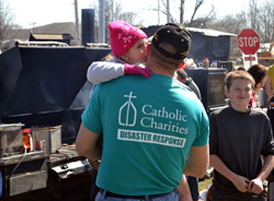 A Catholic Charities Disaster Response team member receives a kiss from a young girl in Henryville on March 6. Catholic Charities officials are committed to assisting people in the tornado-ravaged area of southern Indiana for as long as needed. (Photo by David Siler)