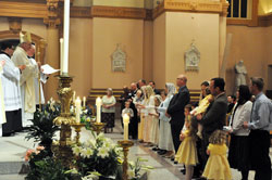 Bishop Christopher J. Coyne, second from left, apostolic administrator, receives a profession of faith from 17 Anglican Christians during an April 7 Easter Vigil Mass at SS. Peter and Paul Cathedral in Indianapolis. They were the fourth group to join the Personal Ordinariate of the Chair of St. Peter, which functions as a diocese for former Anglicans in the U.S. and Canada. Also pictured at the far left making a profession of faith are two candidates who were received into the Latin Rite of the Church. (Photo by Sean Gallagher)