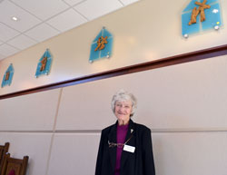 Franciscan Sister Norma Rocklage stands near four of the Stations of the Cross that were dedicated in her honor for the chapel at Cardinal Ritter Jr./Sr. High School in Indianapolis. (Submitted photo)