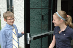 Saben Fletcher opens the door for Grace Meier at St. Michael School in Greenfield, displaying one of the thoughtful acts that earned him the distinction as the Gentleman of the Year for the school’s Crusaders for Christ Gentlemen’s Club—a club that seeks to develop faith, values and manners in male middle school students. Both Saben and Grace are seventh-grade students at St. Michael School. (Photo by John Shaughnessy)
