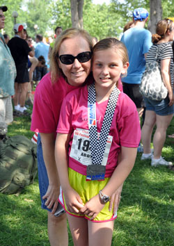 After she finished the OneAmerica 500 Festival Mini-Marathon on May 5, 10-year-old Abby Allen enjoys a moment to smile with Michelle Combs. Abby ran the 13.1-mile race to raise funds to help pay for uninsured, alternative cancer treatments for Combs, a mother of two. (Submitted photo)
