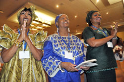 Melba Myers, from left, Barbara Parks and Grace Okonta, all of the Diocese of Kansas City-St. Joseph, Mo., sing and clap their hands at the beginning of the opening Mass of the National Black Catholic Congress at the JW Marriott in Indianapolis on July 19, which was attended by approximately 2,200 black Catholics from across the country. (Photo by Sean Gallagher)