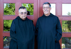 Benedictine Brother Angelo Vitale, left, and Benedictine Brother Flavian Swank pose in front of the Archabbey Church of Our Lady of Einsiedeln in St. Meinrad. The brothers, along with Benedictine Father Matthias Neuman (not pictured), recently celebrated 50 years as monks of Saint Meinrad Archabbey. (Photo courtesy of Saint Meinrad Archabbey)