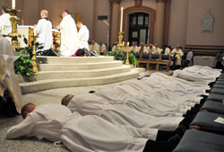 The second class of men to be ordained as permanent deacons for the Archdiocese of Indianapolis lay prostrate in prayer on June 23 at SS. Peter and Paul Cathedral in Indianapolis. Meetings will start soon to help men learn about the diaconate and discern if God might be calling them to this vocation. (File photo by Sean Gallagher)