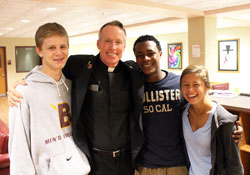 Jesuit Father Jack Dennis, second from left, the new president of Brebeuf Jesuit Preparatory School in Indianapolis, poses on Sept. 19 with sophomores Michael Vieth, Levante Bellamy and Olivia Malatestinic. (Submitted photo)