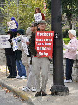 St. Rose of Lima parishioner Michael Dotson of Franklin holds a red and white pro-life sign supporting mothers that are experiencing crisis pregnancies during the Central Indiana Life Chain on Oct. 7 along North Meridian Street in Indianapolis. (Photo by Mary Ann Garber)