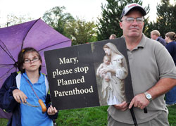 Our Lady of the Most Holy Rosary parishioners Tamara Richards, left, and her father, Kevin Richards, of Indianapolis hold a pro-life sign as they pray in front of the Planned Parenthood abortion facility in Indianapolis on Sept. 26 as part of the fall rally for the “40 Days for Life” campaign. (Photo by Mary Ann Garber)