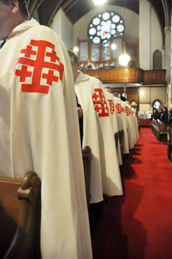 Knights of the Holy Sepulchre wearing their distinctive white cape with a red Jerusalem cross stand during a Mass celebrated on Sept. 30 at St. John the Evangelist Church in Indianapolis. (Photo by Sean Gallagher)