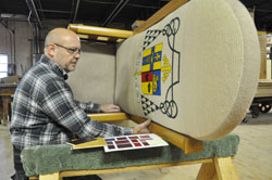 Bob Hermann, the owner of Wm. Hermann and Son, a woodworking company in Indianapolis, takes apart Archbishop Emeritus Daniel M. Buechlein’s tapestry-covered cathedra on Nov. 7 to rebuild it with Archbishop Joseph W. Tobin’s coat of arms carved in wood in time for the new archbishop’s installation Mass on Dec. 3 at SS. Peter and Paul Cathedral in Indianapolis. (Photo by Mary Ann Garber)