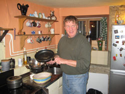 Then-Redemptorist Father Joseph Tobin washes dishes during a May 8, 2010, visit to a home in Hargrave, England. The people who lived there were relatives of Patricia Merrikin, the wife of John Heineman, an American friend of Archbishop Tobin who lives in Rome. (Submitted photo)