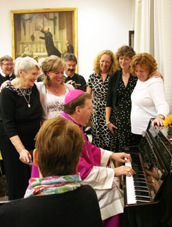 Archbishop Joseph W. Tobin plays a song on a piano for members of his family on Oct. 10, 2010, at a Redemptorist house in Rome during a celebration of his ordination as an archbishop, which took place the previous day. Listening to him play are, from left, his mother, Marie Tobin; sister, Ann Tobin Levigne; sister, Margo Tobin; sister, Kathy Vandelinder; and sister, Pat Steinhauer. (Submitted photo)