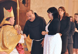 Representing Hispanic Catholics in central and southern Indiana, Franciscan Brother Moises Gutierrez, archdiocesan coordinator of Hispanic ministry, and Angela Valdez, a member of St. Patrick Parish in Indianapolis, greet Archbishop Joseph W. Tobin during the Dec. 3 installation Mass in which he was installed as the sixth archbishop of Indianapolis. (Photo by Sean Gallagher)
