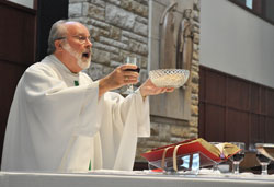 Father Clement Davis, pastor of St. Bartholomew Parish in Columbus, elevates the Eucharist during a Dec. 6 Mass in the Seymour Deanery faith community’s church. (Photos by Sean Gallagher)
