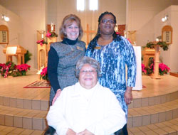 At 83, Teresa Moore smiles after fulfilling her lifelong dream of joining the Catholic Church during a Mass at St. Monica Parish in Indianapolis on Jan. 6. Moore is joined in the photo by, left, Anne Corcoran, parish pastoral associate, and Dabrice Bartet, Moore’s sponsor. (Submitted photo/Kent Hughes)