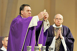 Archbishop Joseph W. Tobin elevates the Eucharist during a March 12 Mass celebrated at SS. Peter and Paul Cathedral in Indianapolis. Concelebrating the Mass was Father Stephen Giannini. The liturgy was an opportunity for Catholics to pray with the archbishop for the 115 cardinals who gathered in the Sistine Chapel that day to begin the balloting to elect a new pope. (Photo by Sean Gallagher)
