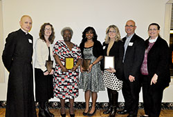 Pro-life volunteers in the Archdiocese of Indianapolis honored on March 14 at the Sanctity of Life Dinner in Indianapolis pose after the fundraising event for the archdiocesan Office for Pro-Life Ministry. They are Stephanie Hunter, second from left, Beverly Jones, Pauline Kattady, and Patty and Steve Dlugosz. Pictured with them are Father John Hollowell, left, keynote speaker at the dinner, and Patty Arthur, right, administrative assistant in the Office for Pro-Life Ministry. (Photo by Sean Gallagher)