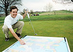 Luke Bielawski with a golf club and a map