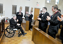 Archbishop Emeritus Daniel M. Buechlein gives a thumbs up to the seminarians and guests who applaud him after an April 21 prayer service at Bishop Simon Bruté College Seminary in Indianapolis. The retired archbishop was honored after the service for founding the seminary in 2004. (Photo by Sean Gallagher)