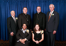 Catholic Charities Indianapolis presented four individuals with Spirit of Service Awards during an April 18 dinner in Indianapolis. Award recipients, seated from left, are Adonis Hardin and Amanda Rulong. Standing, from left, are award recipient Paul Corsaro, Archbishop Joseph W. Tobin, Bishop Christopher J. Coyne, and award recipient Gary Ahlrichs. (Photo by Rich Clark)