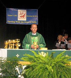 Father Scott Nobbe, pastor of St. John the Baptist Parish in Dover, St. Joseph Parish in St. Leon, St. Martin Parish in Yorkville and St. Paul Parish in New Alsace, leads members of the Batesville Deanery faith communities in worship during a Mass celebrated on Oct. 7, 2012, at East Central High School in St. Leon to kick off the observance of the Year of Faith. During the Year of Faith, the parishes have started their Evangelization Team that will reach out in the coming months to inactive Catholics in the area. (Submitted photo)