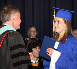Principal John Atha of Bishop Chatard High School in Indianapolis presents a diploma to Arden Burch during the school’s 2012 graduation. (Submitted photo)