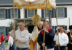 Franciscan Father Frank Jasper, then-temporary administrator of Holy Family Parish in Oldenburg, carries a monstrance containing the Blessed Sacrament during the 160th annual Corpus Christi procession through Oldenburg on June 11, 2006. (File photo by Mary Ann Wyand)