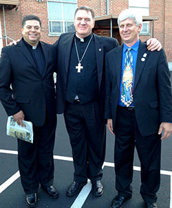 Father Juan Jose Valdes, left, administrator of St. Mary Parish in Lanesville, Archbishop Joseph W. Tobin, and Deacon Rick Cooper of St. Mary Parish in Lanesville pose for a photo after the Miter Society Mass on May 22 at St. Mary Church in Lanesville. (Photo by Leslie Lynch)