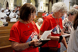 Margie Schmitz, left, and Pat Vesper, both members of St. Luke the Evangelist Parish in Indianapolis, recite a prayer for religious liberty at the end of a June 22 Mass at St. John the Evangelist Church in Indianapolis. (Photo by Sean Gallagher)