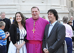 Sarah and Greg Hempstead, members of Immaculate Heart of Mary Parish in Indianapolis, are shown with Archbishop Joseph W. Tobin outside of St. Peter’s Basilica at the Vatican on June 29. The Hempsteads traveled to Italy to attend the pallium Mass with a group from Marian University in Indianapolis.	(Photo	by John Shaughnessy)