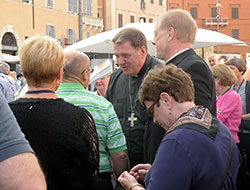 Surrounded in the Piazza Navona square by the 80 people who made a pilgrimage with him to Rome, Archbishop Joseph W. Tobin talks with Robert Van Note, a member of St. Pius X Parish in Indianapolis, on June 26. The Piazza Navona is built on the site of an ancient Roman stadium from the first century. (Photo by John Shaughnessy)