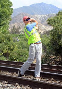 Luke Bielawski watches the flight of a shot after hitting his golf ball off railroad tracks in California during the early part of his cross-country adventure. (Submitted photo)