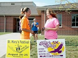 Katina Tekulve, left, and Kristy Lowe discuss plans for the “On Eagle’s Wings” 5K Run/Walk that will celebrate the lives of Stephen and Denise Butz and Donald and Barbara Horan during the festival at St. Mary Parish in Greensburg on Aug. 24. Tekulve is logistical coordinator of the event while Lowe is the sponsorship coordinator. (Submitted photo)
