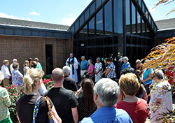 Conventual Franciscan Father Joseph West, pastor of St. Anthony of Padua Parish in Clarksville, blesses the people and the new preschool—a former credit union building located on the parish’s property—on July 14. (Photo by Natalie Hoefer)