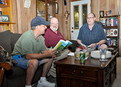 St. Monica Parish members Todd Kowinski, left, Charles “Nick” Georges and Dan Bedillion, three of the eight members of a St. Monica Parish small church communities group, respond to the message they hear in the upcoming Sunday Scriptures at their meeting at Kowinski’s home on Aug. 27. (Photo by Natalie Hoefer)