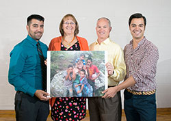 The family of Brooke Lahr holds up a portrait of her with children during a mission trip that she made to Honduras. The family photo was taken during a Sept. 15 gathering at Bellarmine University in Louisville, where Brooke attended college. Brooke’s parents have established a missionary endowment in their daughter’s memory. Pictured from left, Brooke’s brother, Anthony; her mother and father, Colleen and Mark; and her brother, Paul. (Photograph by Sarah Albritton of Serendipity Portraits )