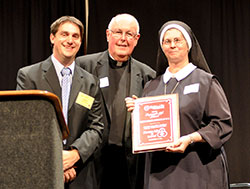 Right to Life of Indianapolis’ 2013 Respect for Life Award is presented to Servants of the Gospel of Life Sister Diane Carollo at the organization’s Celebrate Life dinner at the Indiana Convention Center in Indianapolis on Sept. 17. Making the presentation is Marc Tuttle, president of Right to Life of Indianapolis. Msgr. Joseph Schaedel, pastor of St. Luke the Evangelist Parish in Indianapolis, is also pictured. Sister Diane has devoted her life to the pro-life cause since 1971. (Photo by Natalie Hoefer)