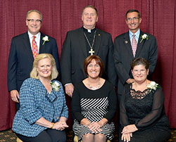 An archdiocesan celebration of Catholic education on Oct. 8 honored four individuals whose Catholic values mark their lives. Sitting, from left, are honoree Sarah Lechleiter, featured speaker Mary McCoy and honoree Julie Bowers. Standing, from left, are honoree John Lechleiter, Archbishop Joseph W. Tobin and honoree Dr. David Wolf. (Photo by Rob Banayote)