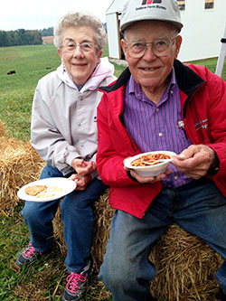 Joan and Pete Schickel, who have hosted the New Albany Deanery’s fall youth Mass at their family farm since 1983, enjoy dinner. (Photo by Leslie Lynch)