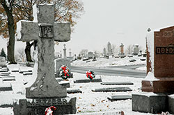 Gravestones are adorned with Christmas wreaths at Holy Cross/St. Joseph Cemetery in Indianapolis in this file photo from 2005. The cemetery is one of seven Catholic cemeteries owned by the Archdiocese of Indianapolis.. (Archive photo by Mary Ann Garber)
