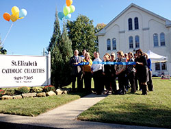 Shown at the Oct. 10 ribbon cutting ceremony for St. Elizabeth Catholic Charities New Albany’s new social services building are, left, Mayor Jeff Gahan; Indiana State Rep. Ed Clere; Agency Director Mark Casper; Council President Karen Schueler; Father William Ernst, First President and CEO Wendy Dant Chesser; and various St. Elizabeth council members and first ambassadors. (Submitted photo)