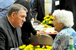 Archbishop Joseph W. Tobin speaks with Teresa Horan, a member of St. Mary Parish in Greensburg, at the Catholic Community Foundation (CCF) annual meeting on Oct. 30 at the Archbishop O’Meara Catholic Center in Indianapolis. Her son, Donald Horan, a past CCF board of trustees’ member, died in a plane crash last December with his wife, Barbara, and their friends Stephen and Denise Butz. All were members of St. Mary Parish in Greensburg. (Photo by Natalie Hoefer)