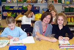 Kindergarten teacher Teresa Minton shares a smile with two of her students, Simon Toth and Molly Campbell, at Nativity of Our Lord Jesus Christ School in Indianapolis. (Submitted photo)