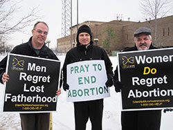 Jim Baily, left, a member of St. Patrick Parish in Terre Haute, Father John Hollowell, pastor of Annunciation Parish in Brazil and sacramental minister of Sacred Heart of Jesus Parish in Terre Haute, and Blaine Akers, a member of Annunciation Parish in Brazil, hold pro-life signs during an hour of prayer in front of the Vigo County Court House in Terre Haute on Jan. 22 to peacefully mark the 41st anniversary of the U.S. Supreme Court’s Jan. 22, 1973, Roe v. Wade and Doe v. Bolton decisions that legalized abortion across the country. (Submitted photo by Tom McBroom)
