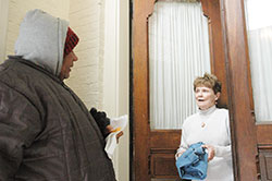 After giving him a dish of lasagna and a pair of pants, volunteer Kathleen Murphy takes time to talk with a visitor to the Garden Door Ministry at St. John the Evangelist Parish in Indianapolis. During this brutal winter in Indiana, the Garden Door Ministry is one of the Catholic efforts that have reached out to the homeless and other people in need. (Photo by John Shaughnessy)