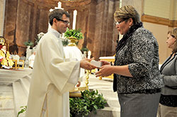 Lisa Roll, right, receives holy oils from transitional Deacon Benjamin Syberg during the annual archdiocesan chrism Mass celebrated on April 15 in SS. Peter and Paul Cathedral in Indianapolis. Roll received the oils for her faith community, St. Michael Parish in Bradford in the New Albany Deanery. (Submitted photo)