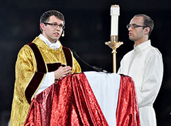 Transitional Deacon Benjamin Syberg proclaims the Gospel at the closing Mass for the National Catholic Youth Conference at Lucas Oil Stadium in Indianapolis on Nov. 23, 2013. He will be ordained to the priesthood on June 7 at SS. Peter and Paul Cathedral in Indianapolis. (File photo by Sean Gallagher)